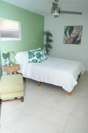 a bedroom with a bed table and chair