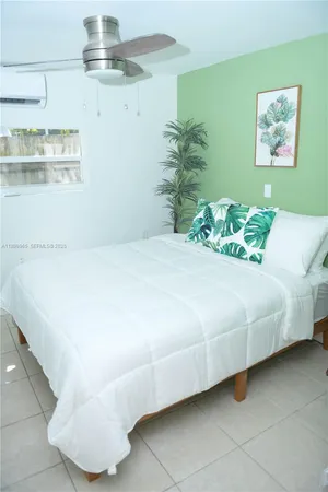 a bedroom with a bed and a painting on the wall