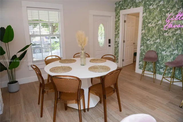 a dining room with furniture potted plants and wooden floor