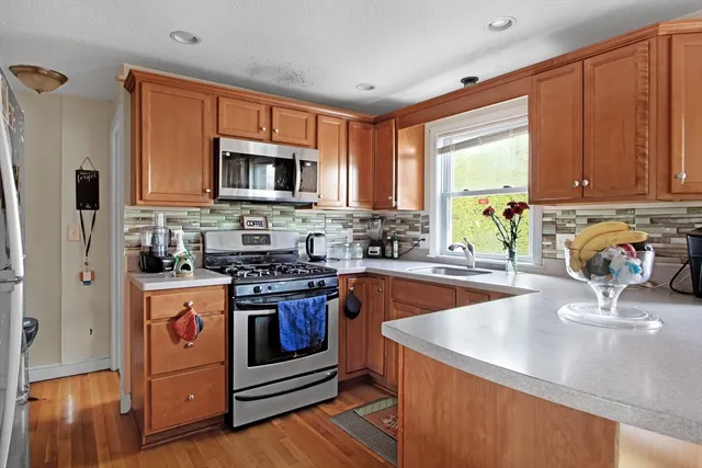a kitchen with stainless steel appliances granite countertop a stove a sink and a microwave