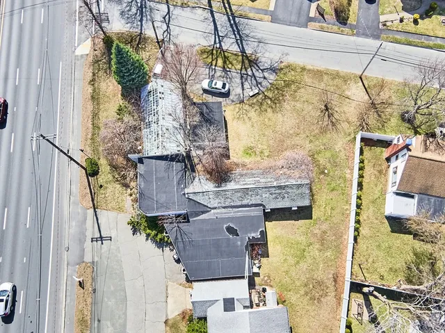 an aerial view of residential houses with outdoor space and parking