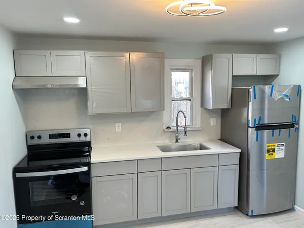 a kitchen with stainless steel appliances a stove a refrigerator sink and cabinets