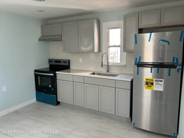 a kitchen with stainless steel appliances a refrigerator a sink a stove and cabinets