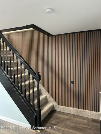 a view of staircase with railing and white walls