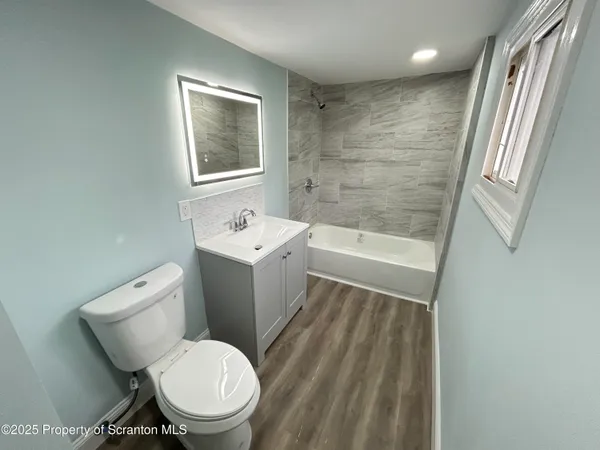 a white toilet sitting next to a bath tub