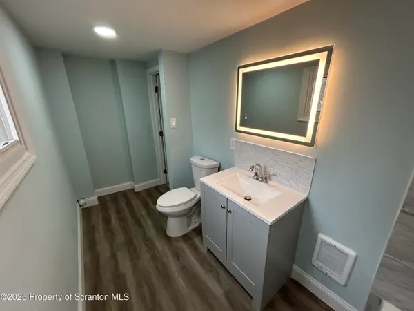 a bathroom with a toilet sink and mirror