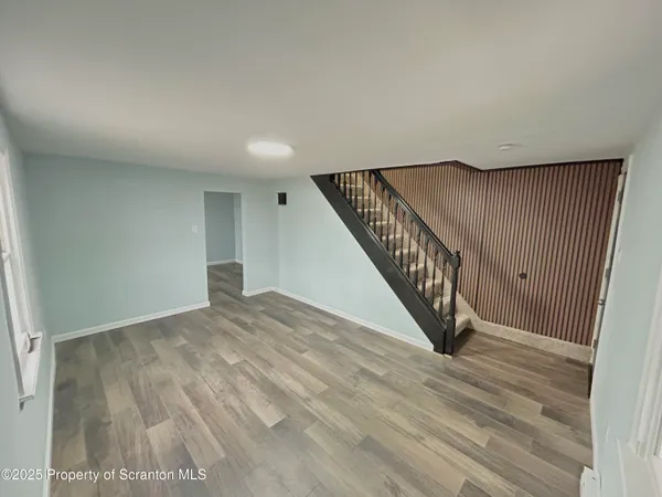 a view of entryway and hall with wooden floor