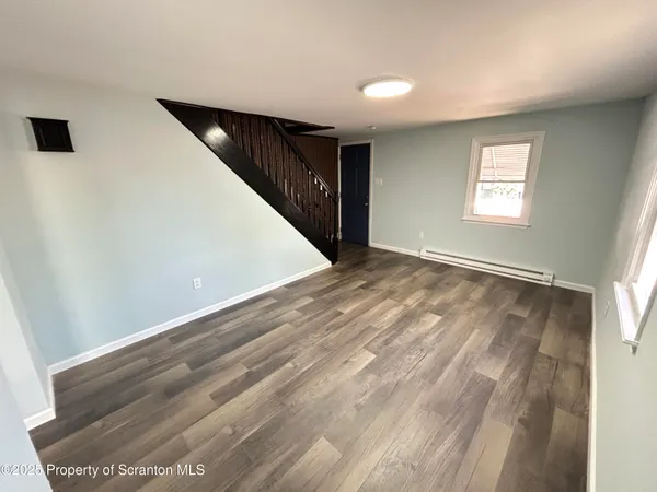a view of an empty room with wooden floor