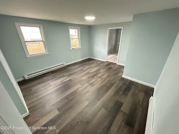 wooden floor in an empty room with a window