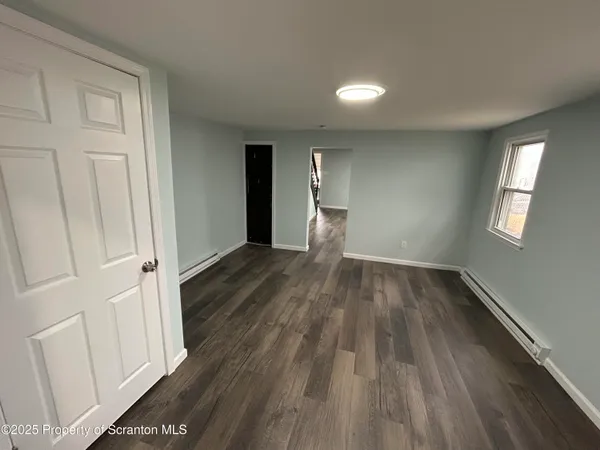 a view of a room with wooden floor and window