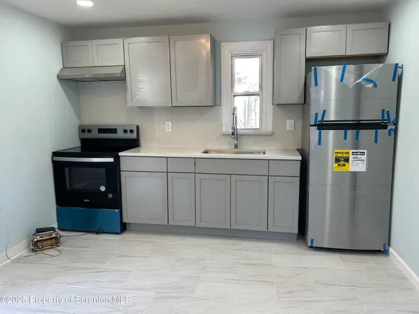 a kitchen with stainless steel appliances granite countertop a refrigerator sink and stove