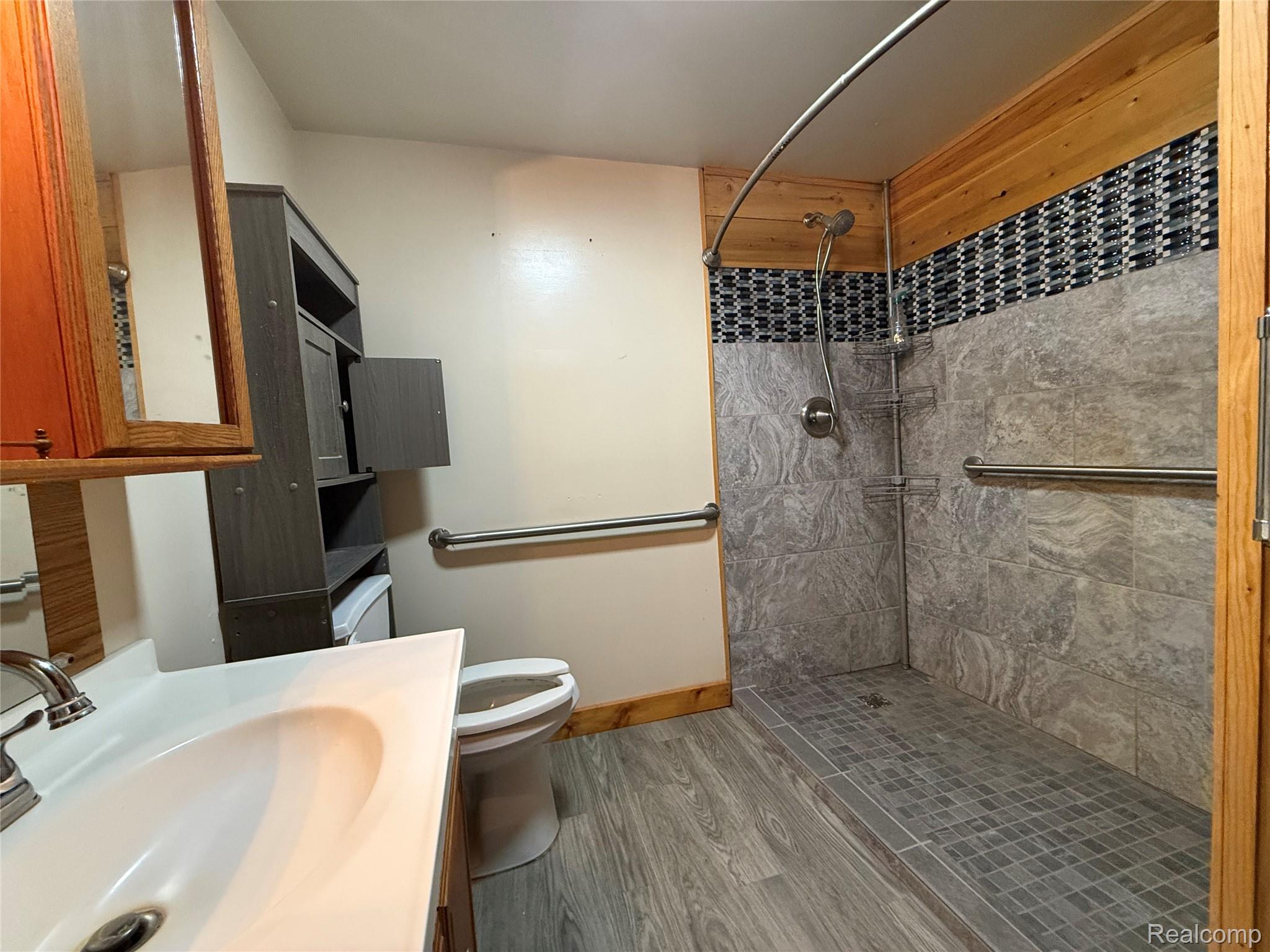 4126 Montgomery Road Marlette, MI 48453 - Photo 9 of 13 Full bathroom with tiled shower, vanity, and wood finished floors