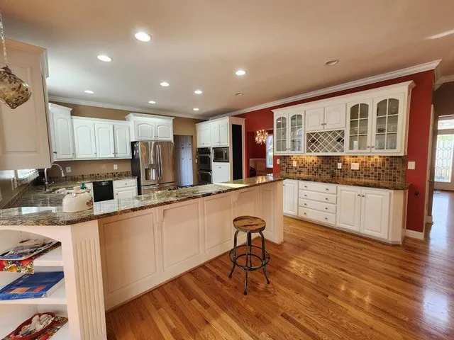 a open kitchen with stainless steel appliances granite countertop a stove and a sink