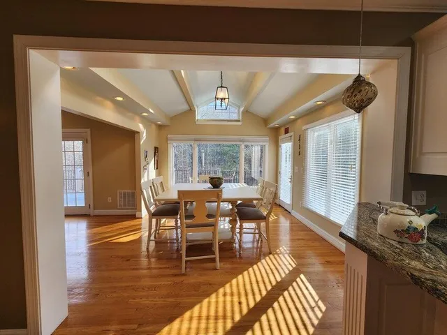 a dining room with wooden floor and large window