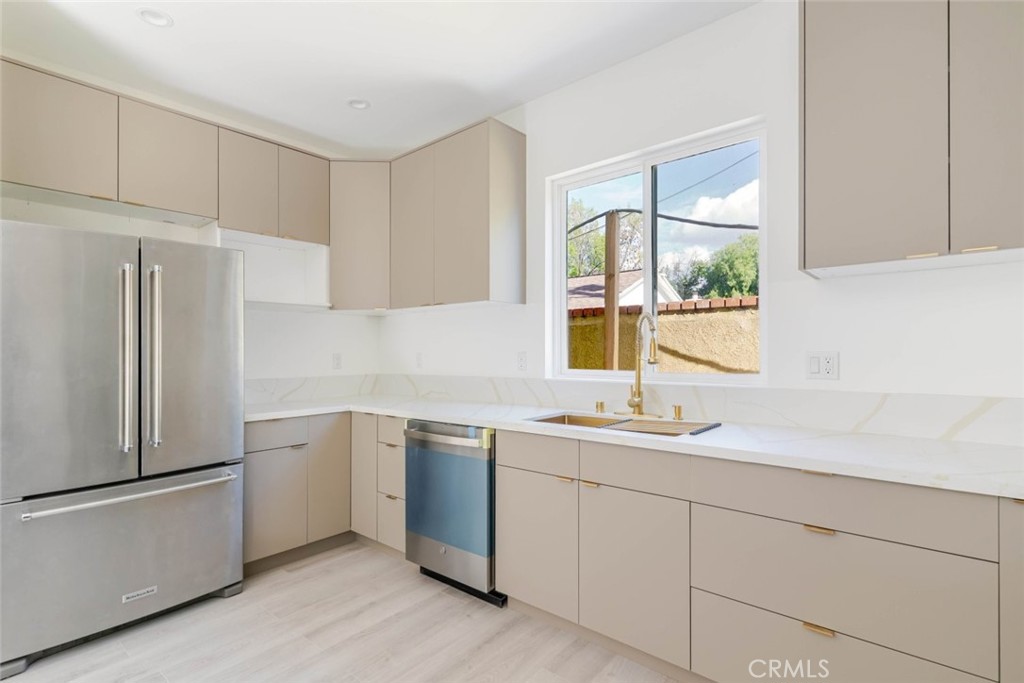 17426 Roscoe Boulevard Northridge, CA 91325 - Photo 12 of 28 a kitchen with a sink cabinets stainless steel appliances and a window