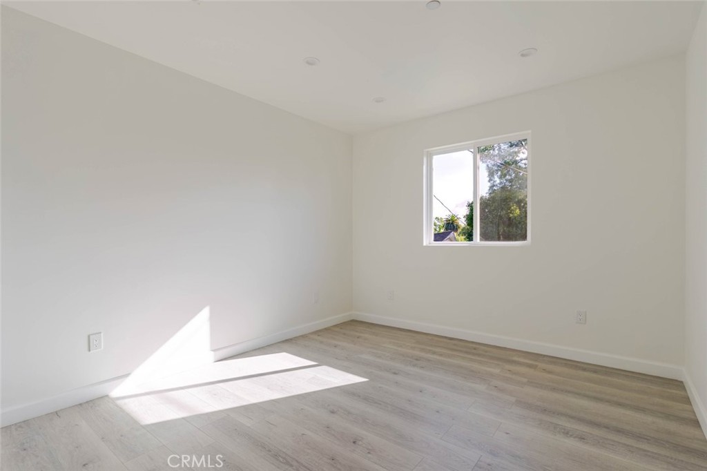 17426 Roscoe Boulevard Northridge, CA 91325 - Photo 18 of 28 an empty room with wooden floor and windows
