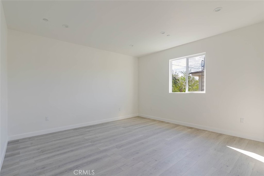 17426 Roscoe Boulevard Northridge, CA 91325 - Photo 22 of 28 an empty room with wooden floor and windows