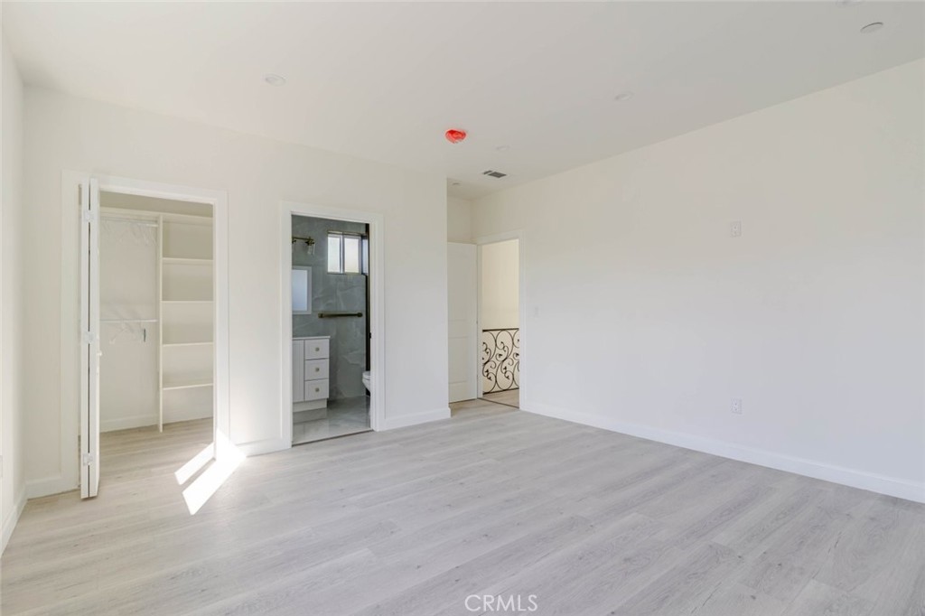 17426 Roscoe Boulevard Northridge, CA 91325 - Photo 24 of 28 a view of an empty room with wooden floor and kitchen space