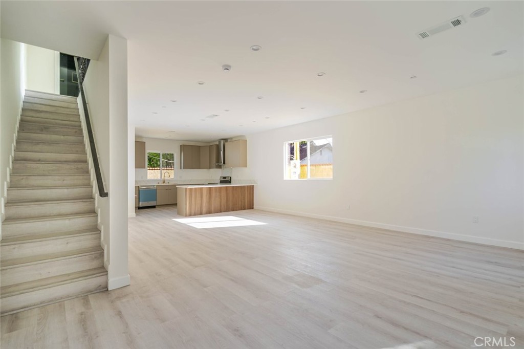 17426 Roscoe Boulevard Northridge, CA 91325 - Photo 6 of 28 a view of an empty room with wooden floor and a window