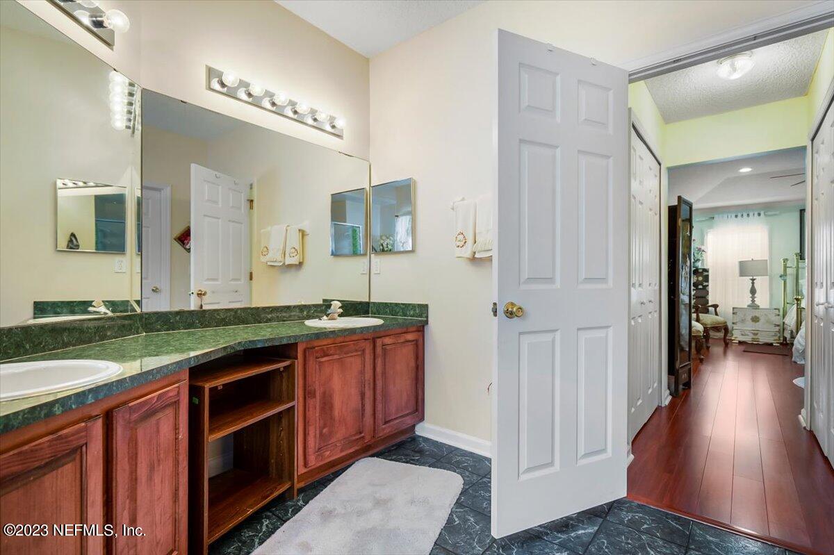 1233 Cactus Cut Road Middleburg, FL 32068 - Photo 20 of 46 a spacious bathroom with a granite countertop sink and a mirror