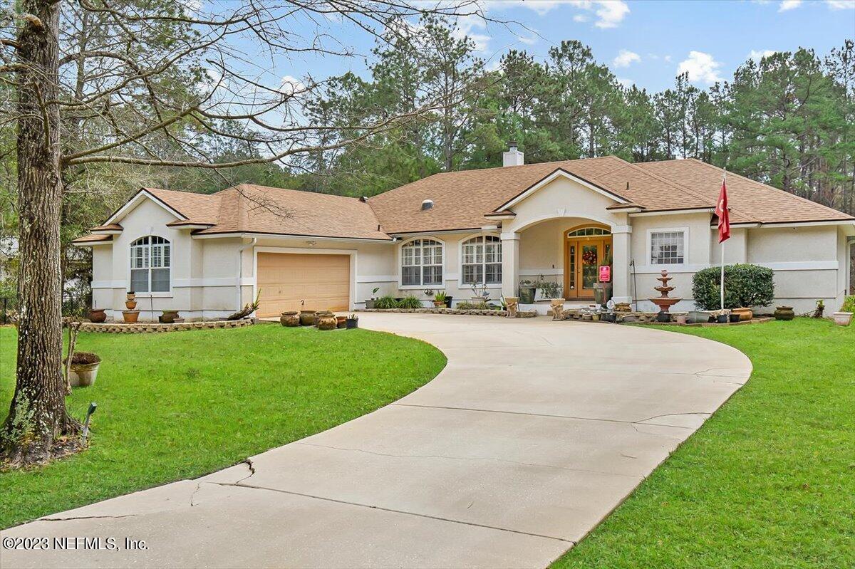 1233 Cactus Cut Road Middleburg, FL 32068 - Photo 2 of 46 a front view of a house with a garden and trees