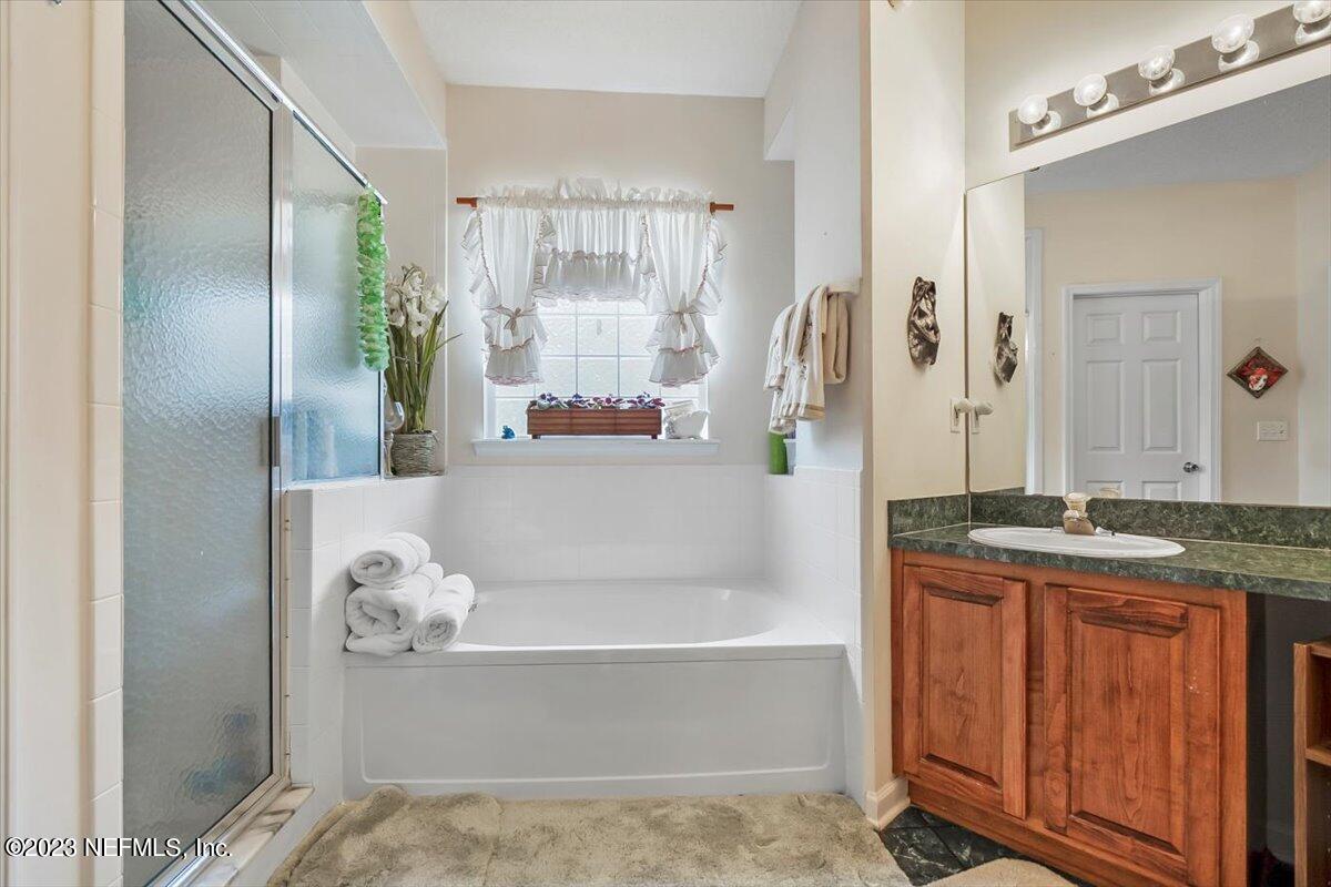 1233 Cactus Cut Road Middleburg, FL 32068 - Photo 21 of 46 a bathroom with a granite countertop bathtub sink and mirror