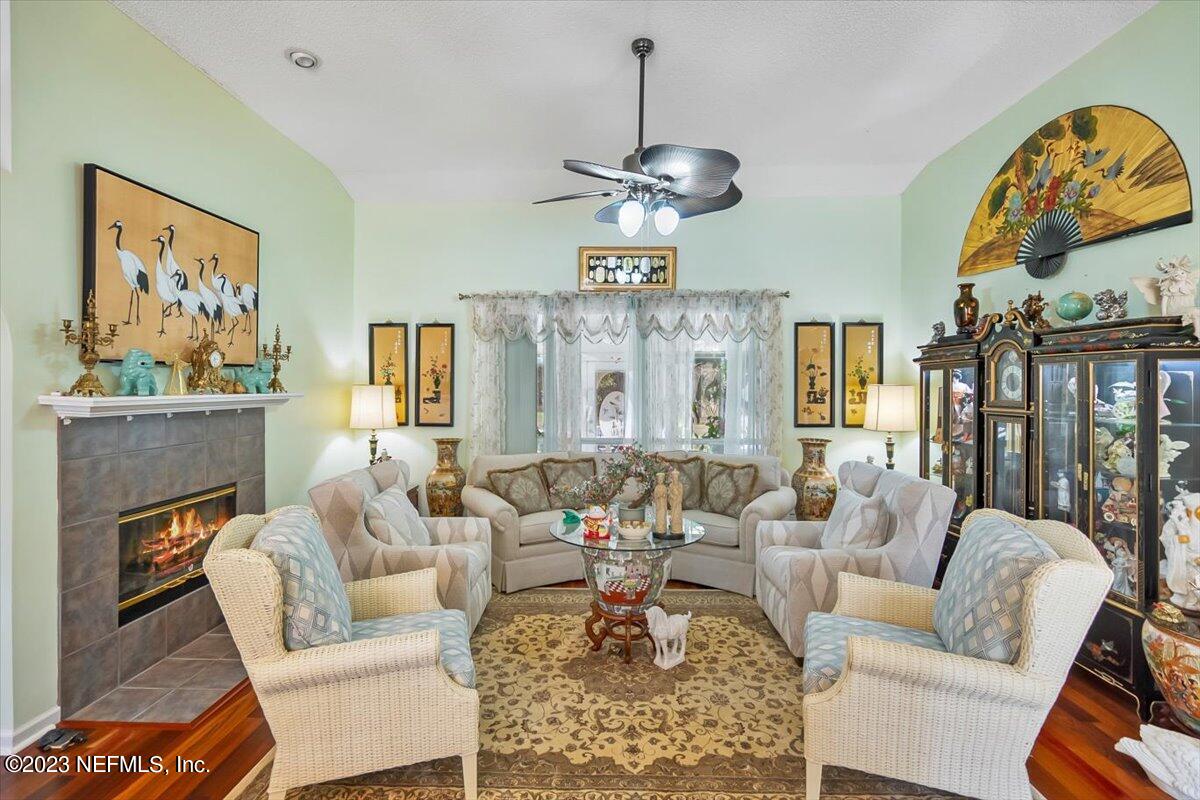 1233 Cactus Cut Road Middleburg, FL 32068 - Photo 23 of 46 a living room with furniture a fireplace and a chandelier