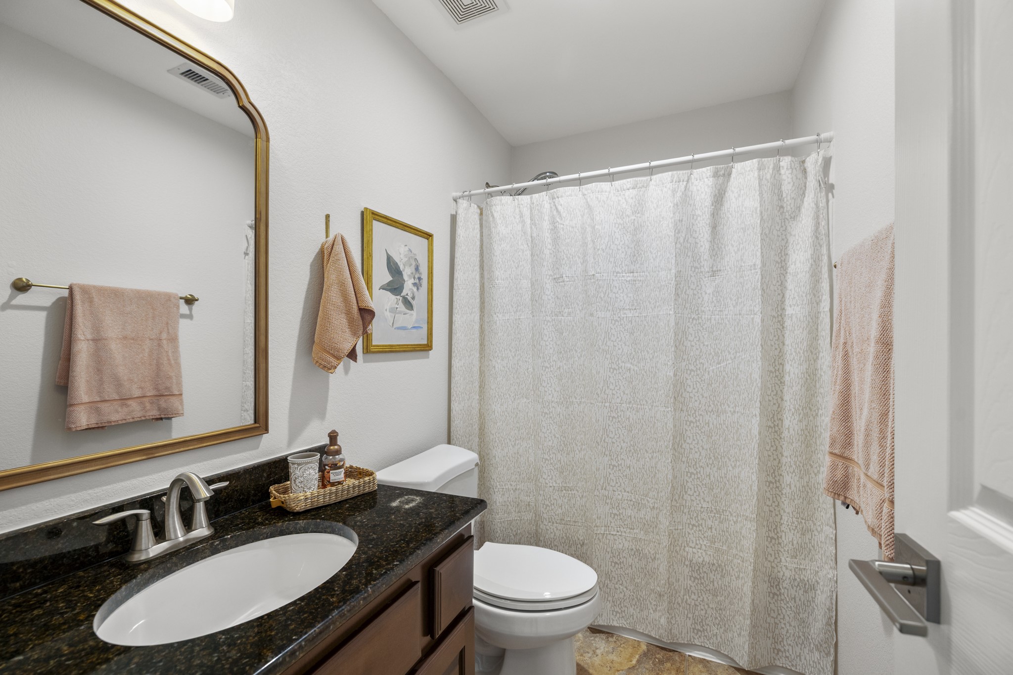 26 Winhall Place The Woodlands, TX 77354 - Photo 31 of 49 a bathroom with a granite countertop sink vanity mirror and toilet