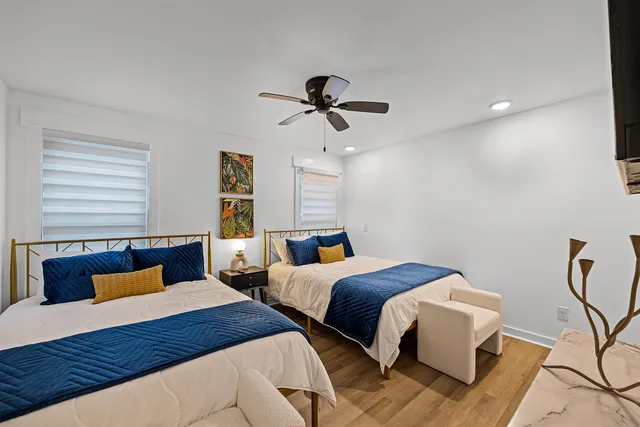 a bedroom with two beds and painting on the wall