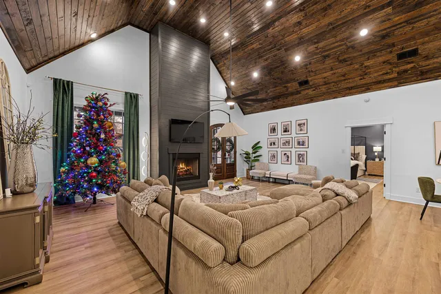 a living room with furniture a fireplace and a chandelier