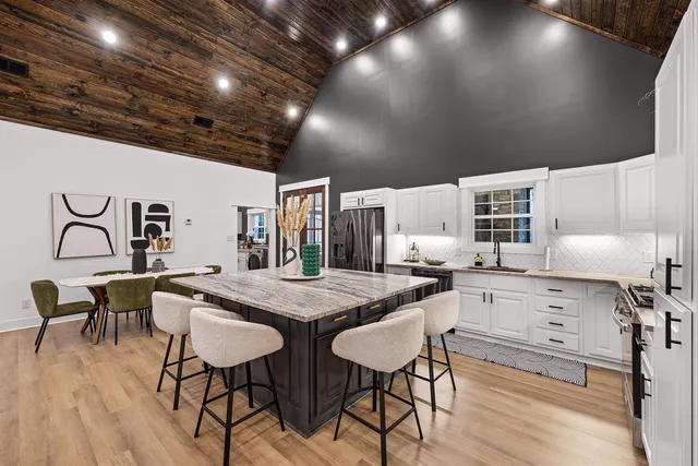 a kitchen with white cabinets and chairs