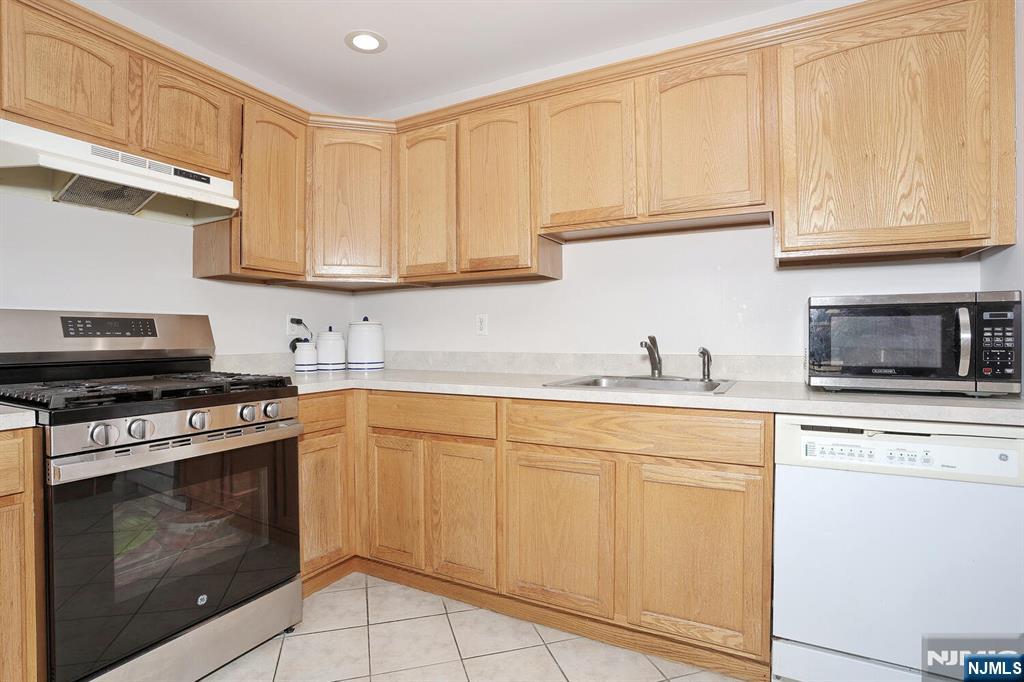 209 Union Street, Unit 4 Lodi, NJ 07644 - Photo 22 of 41 a kitchen with granite countertop white cabinets and stainless steel appliances