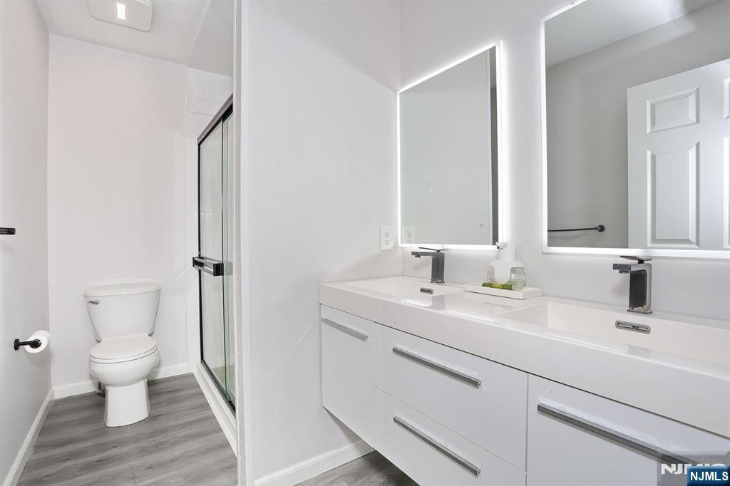 209 Union Street, Unit 4 Lodi, NJ 07644 - Photo 35 of 41 a bathroom with a sink toilet a mirror and shower