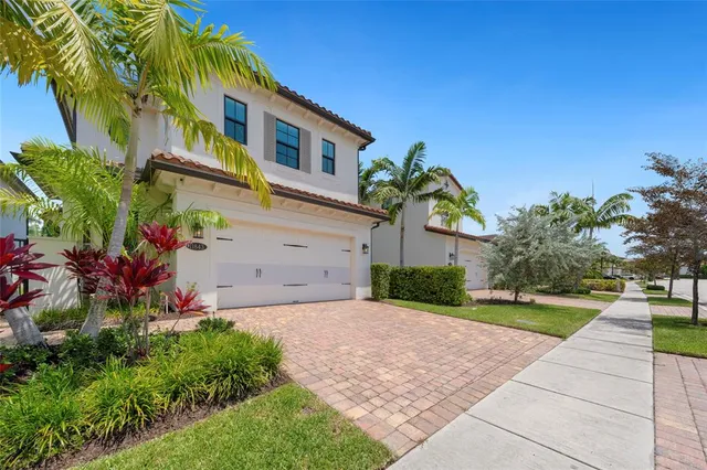 a front view of a house with a yard and potted plants