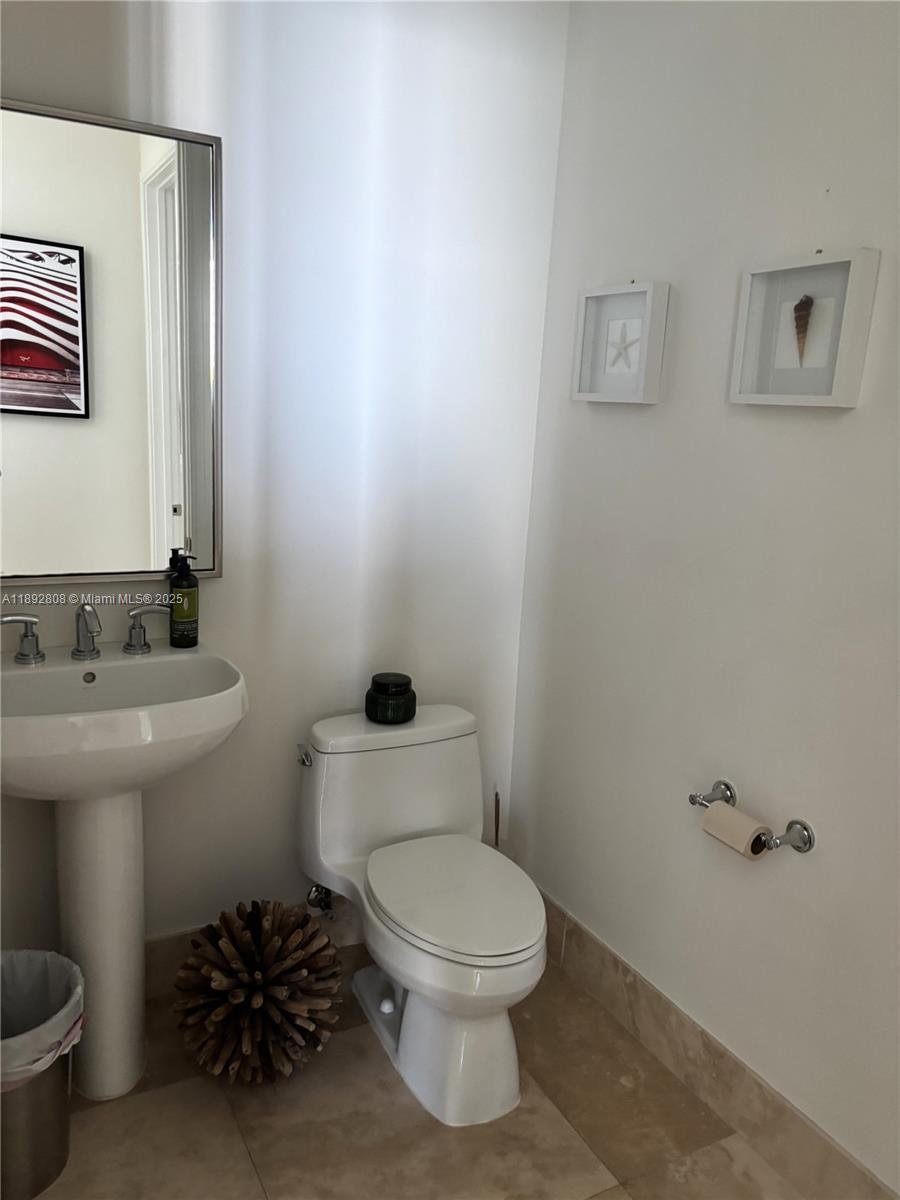 900 Brickell Key Boulevard, Unit 2602 Miami, FL 33131 - Photo 15 of 29 a bathroom with a toilet a sink and mirror