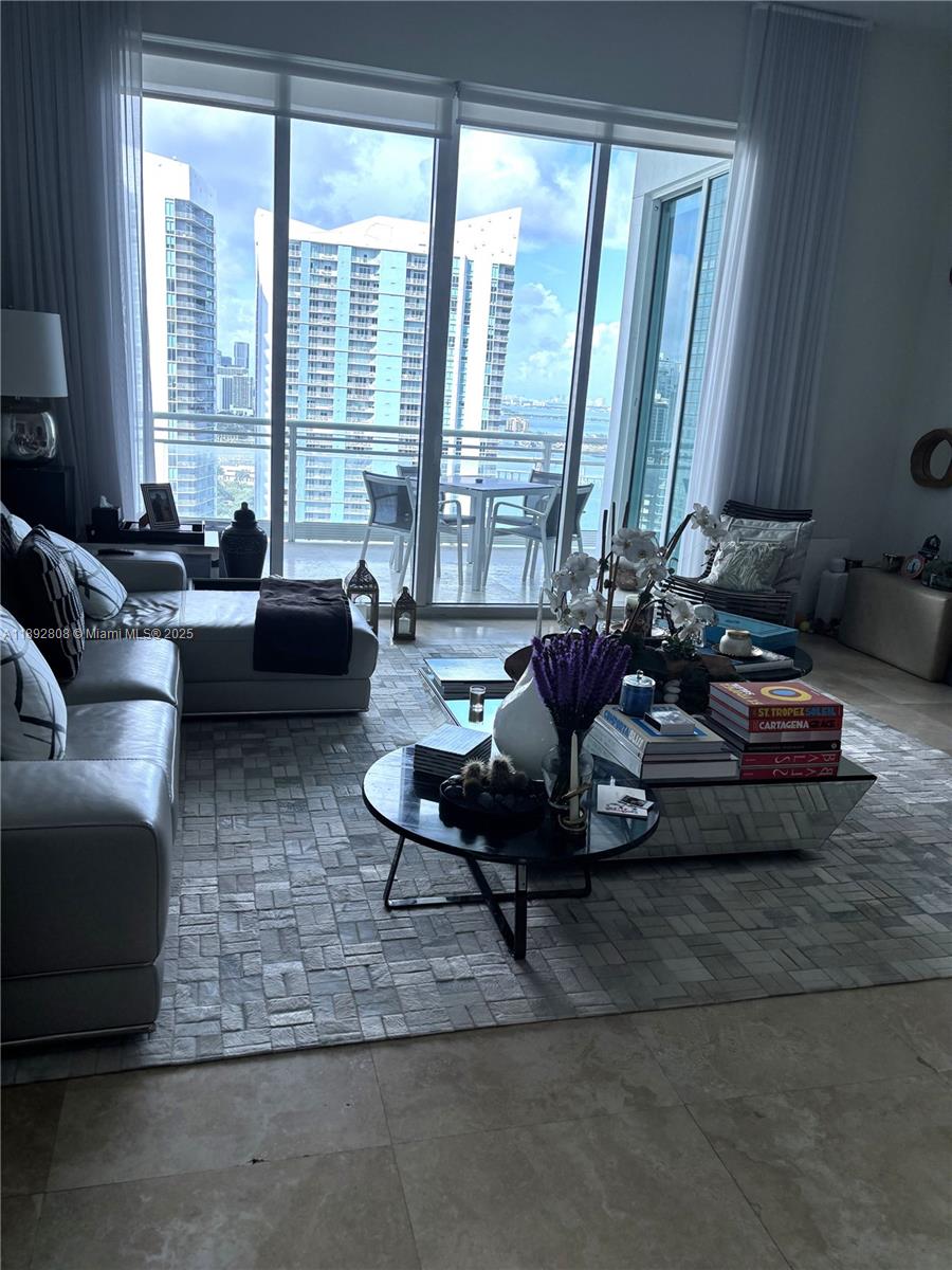 900 Brickell Key Boulevard, Unit 2602 Miami, FL 33131 - Photo 16 of 29 a living room with furniture and large windows