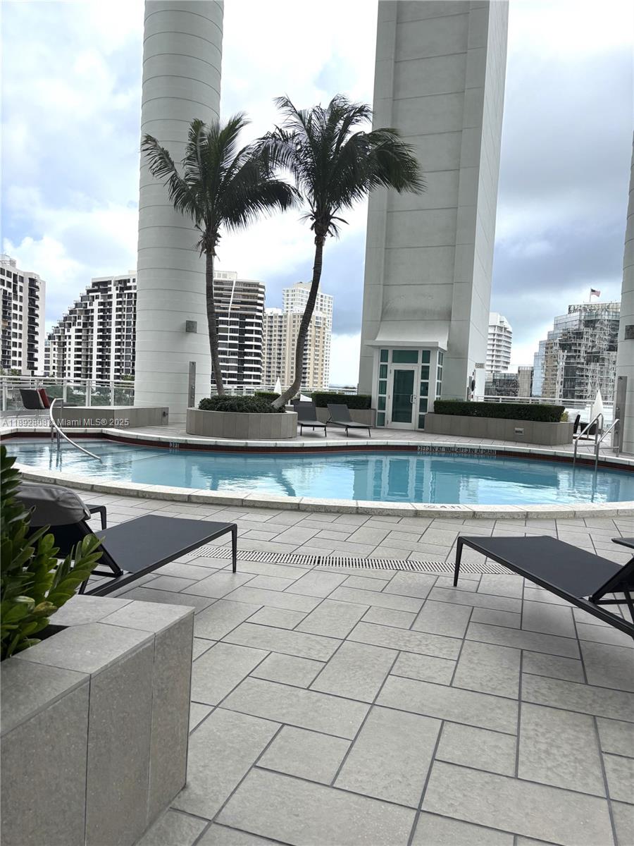 900 Brickell Key Boulevard, Unit 2602 Miami, FL 33131 - Photo 23 of 29 a view of a swimming pool with a lounge chairs