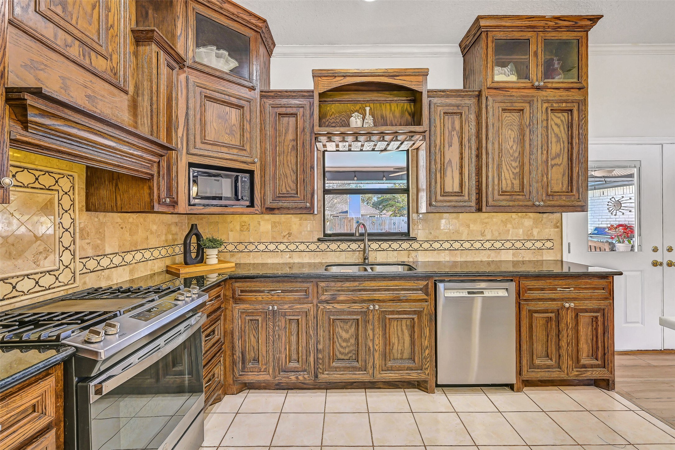4721 Willow Street Pasadena, TX 77586 - Photo 10 of 31 a kitchen with stainless steel appliances granite countertop a stove a sink and a microwave