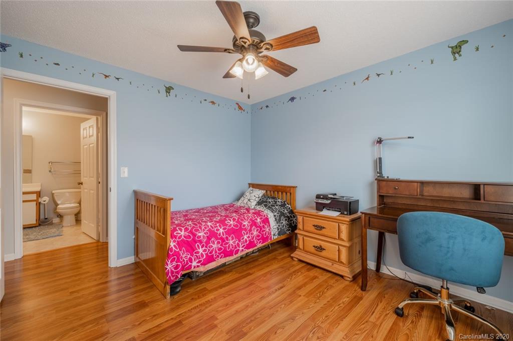5523 Hornaday Road, Unit G Greensboro, NC 27409 - Photo 12 of 20 a bedroom with a bed and a chandelier