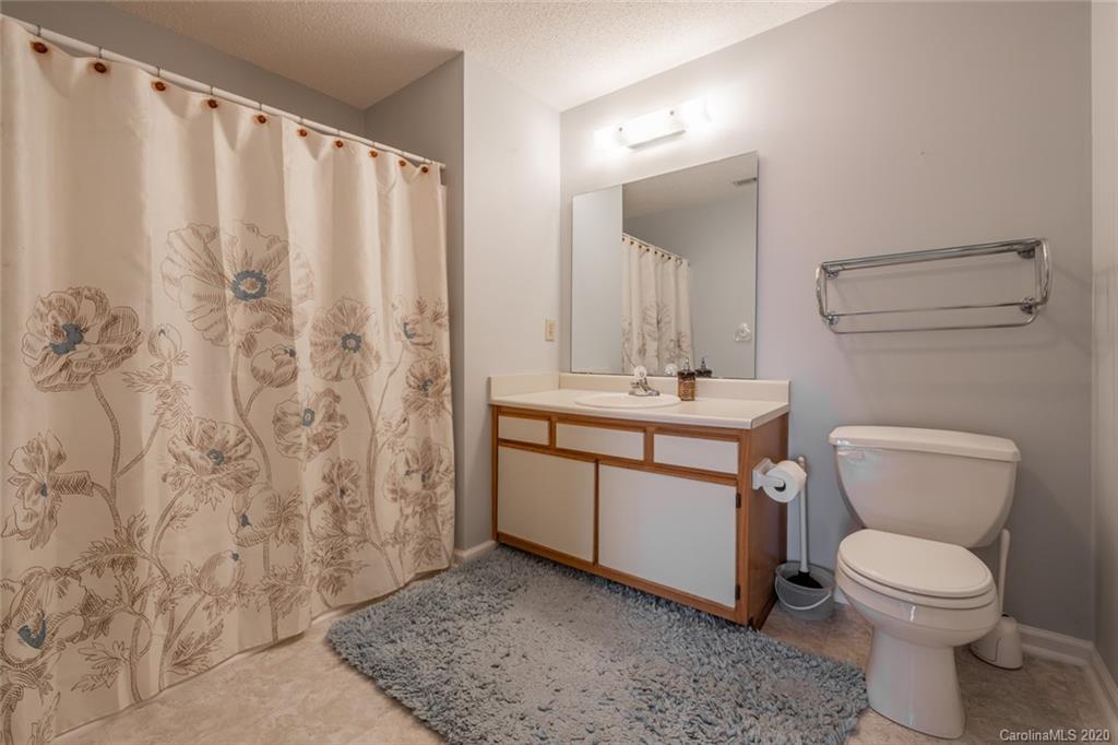 5523 Hornaday Road, Unit G Greensboro, NC 27409 - Photo 13 of 20 a bathroom with a sink a toilet and shower curtain