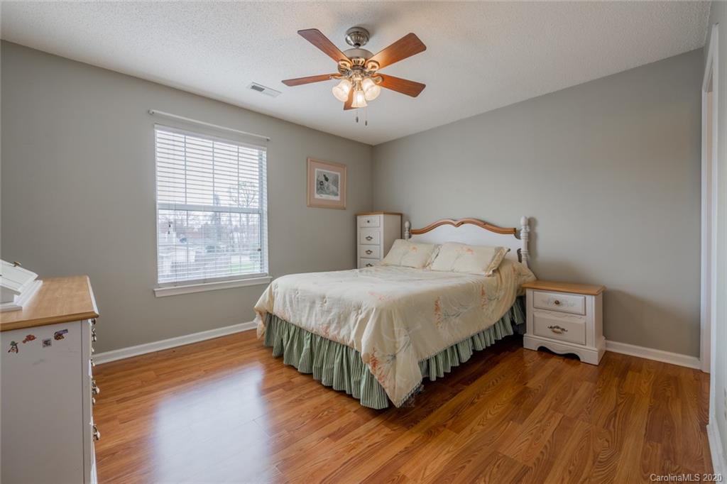 5523 Hornaday Road, Unit G Greensboro, NC 27409 - Photo 14 of 20 a bedroom with a bed and a ceiling fan