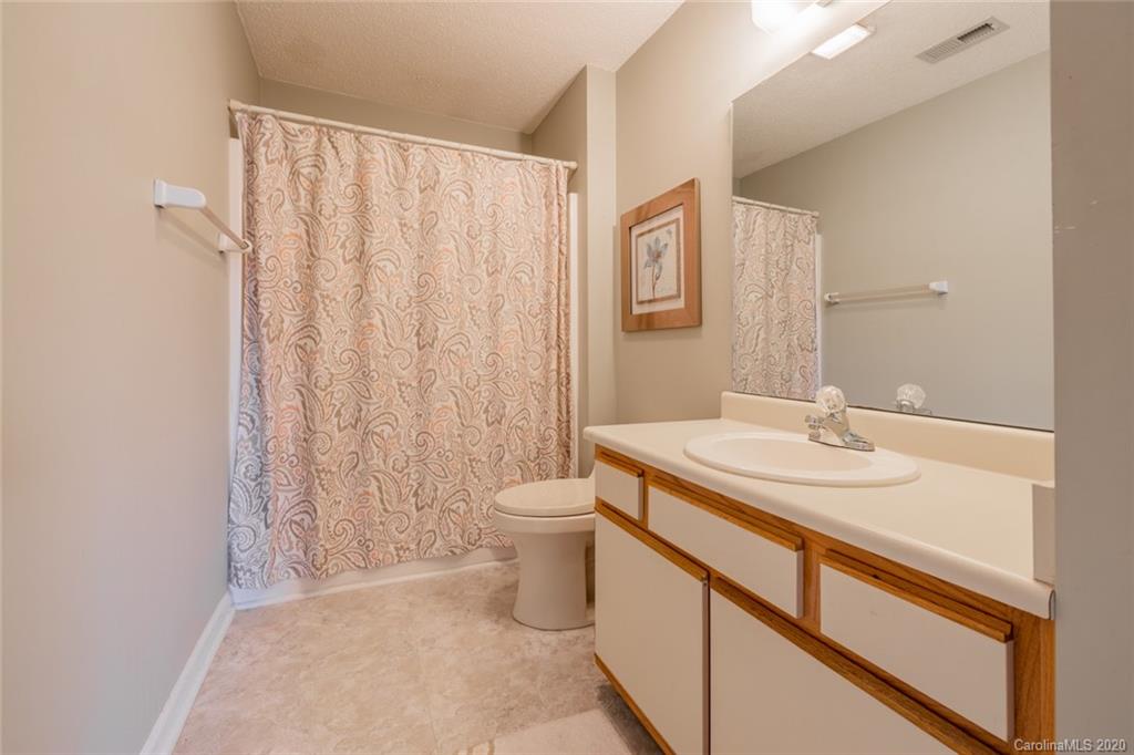 5523 Hornaday Road, Unit G Greensboro, NC 27409 - Photo 16 of 20 a bathroom with a granite countertop sink toilet and mirror