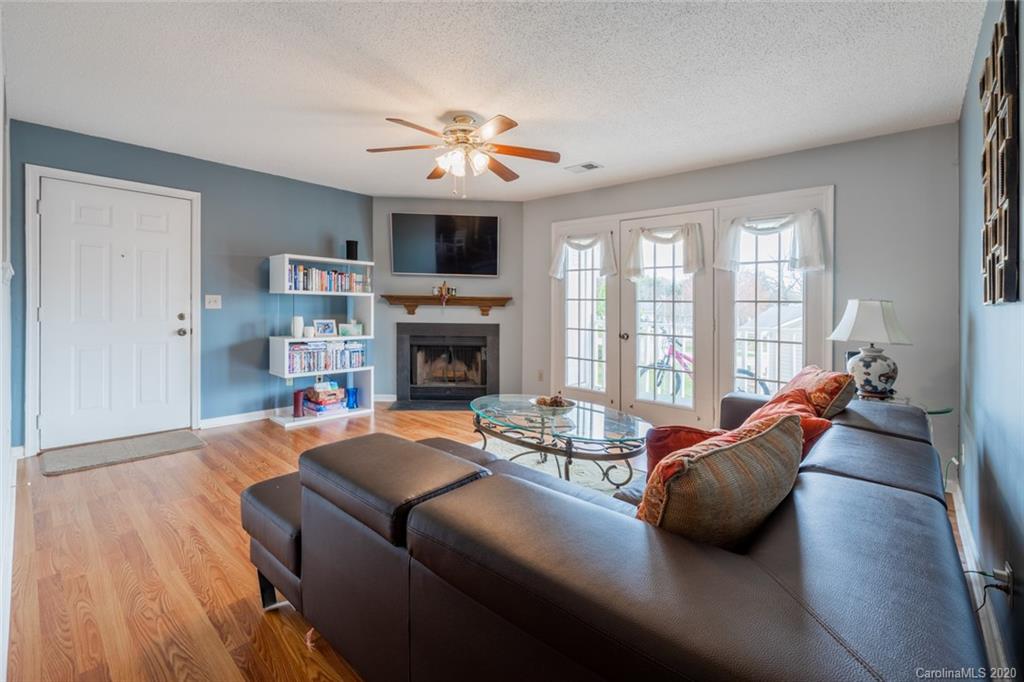 5523 Hornaday Road, Unit G Greensboro, NC 27409 - Photo 5 of 20 a living room with furniture a fireplace and a flat screen tv