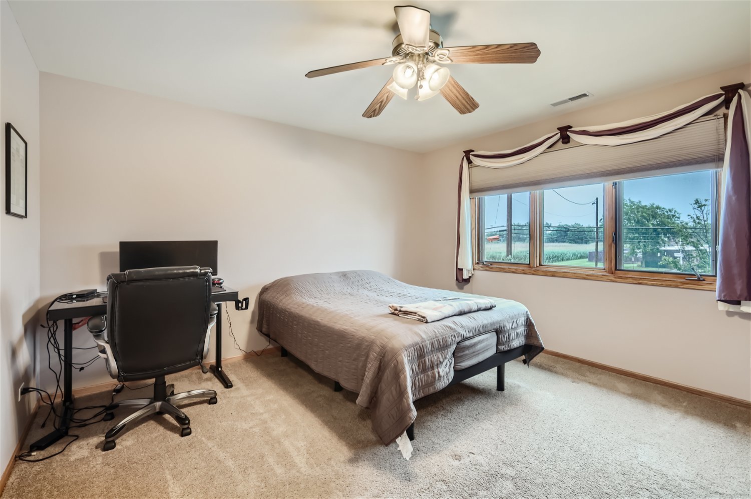 18255 Cork Road Tinley Park, IL 60477 - Photo 20 of 29 a bedroom with a bed a chair and a large window