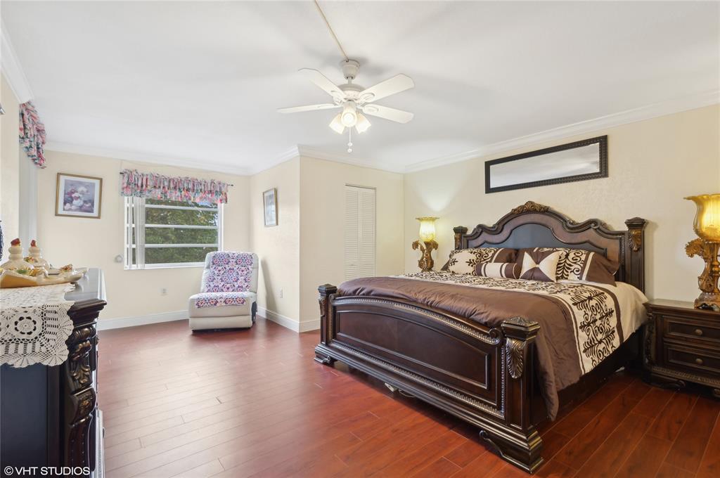 3940 Inverrary Boulevard, Unit 403A Lauderhill, FL 33319 - Photo 11 of 34 a bedroom with a bed and wooden floor