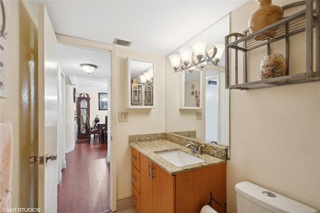 3940 Inverrary Boulevard, Unit 403A Lauderhill, FL 33319 - Photo 22 of 34 a bathroom with a sink a toilet a mirror and shower