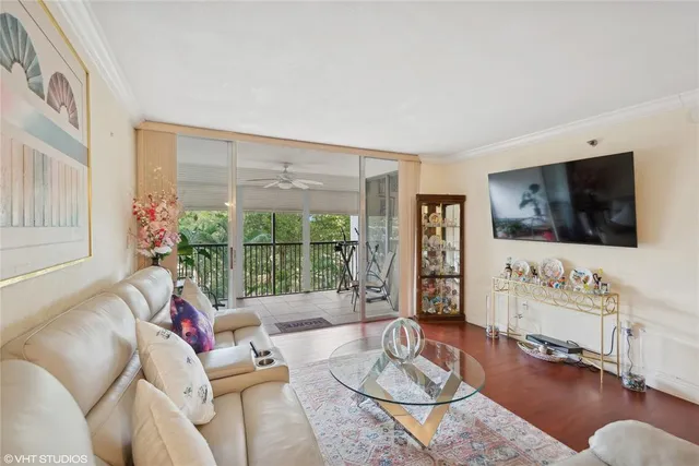 a living room with furniture a flat screen tv and a large window