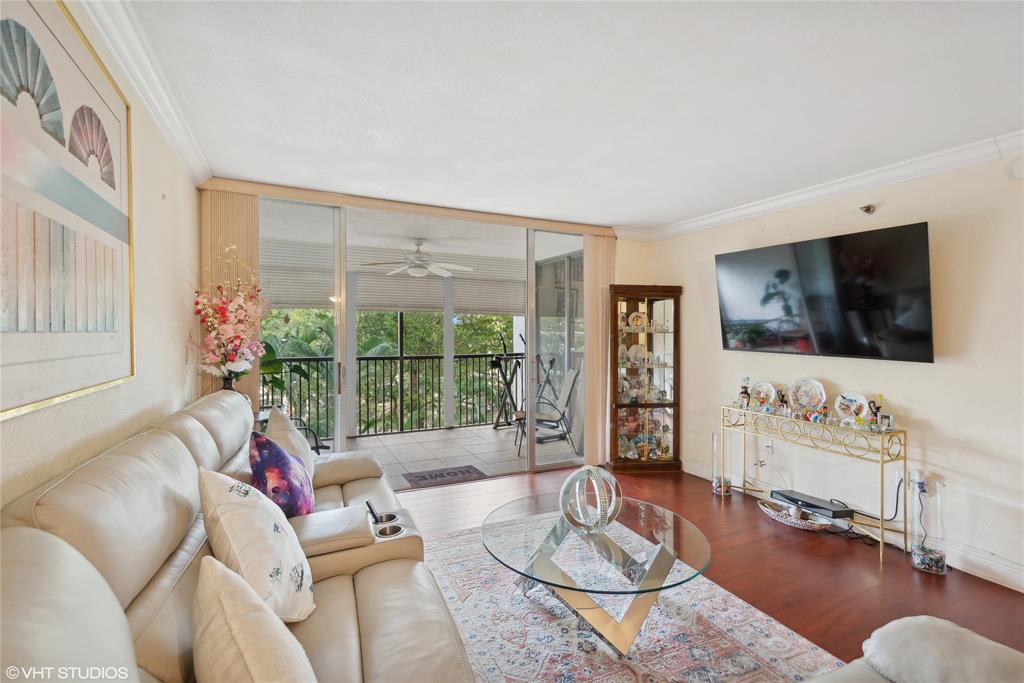3940 Inverrary Boulevard, Unit 403A Lauderhill, FL 33319 - Photo 3 of 34 a living room with furniture a flat screen tv and a large window