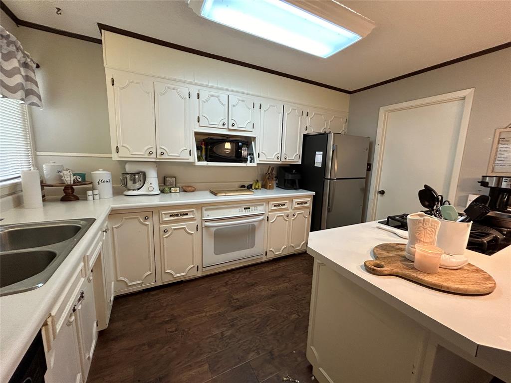 13 Rim Rock Road Goldthwaite, TX 76844 - Photo 9 of 30 a kitchen with white cabinets and white appliances