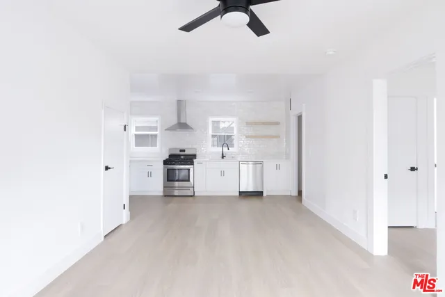 a view of a kitchen with white cabinets and stainless steel appliances